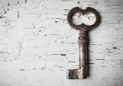 Old style skeleton key on white painted brick background to represent seo keywords