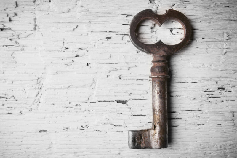 Old style skeleton key on white painted brick background to represent seo keywords