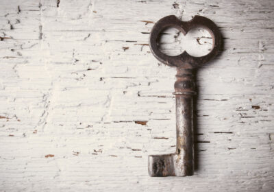 Old style skeleton key on white painted brick background to represent seo keywords